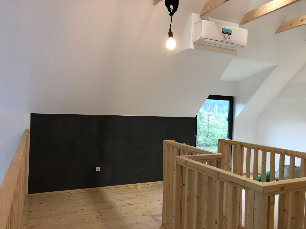 Poddasze z ciemną ścianą i drewnianą balustradą