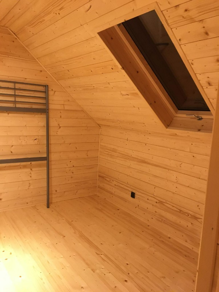 Drewniane wnętrze na poddaszu z oknem połaciowym